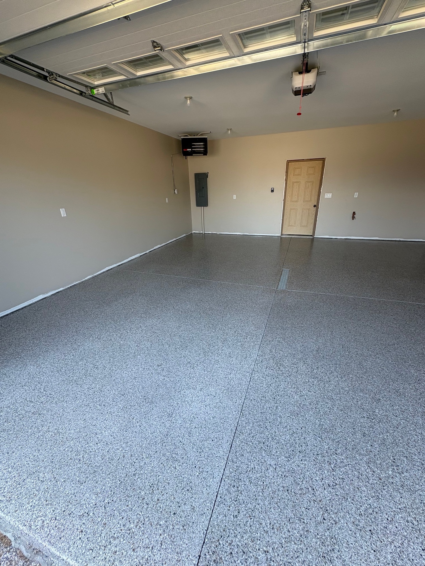 Interior de garagem com pavimento em flocos cinzentos e porta única