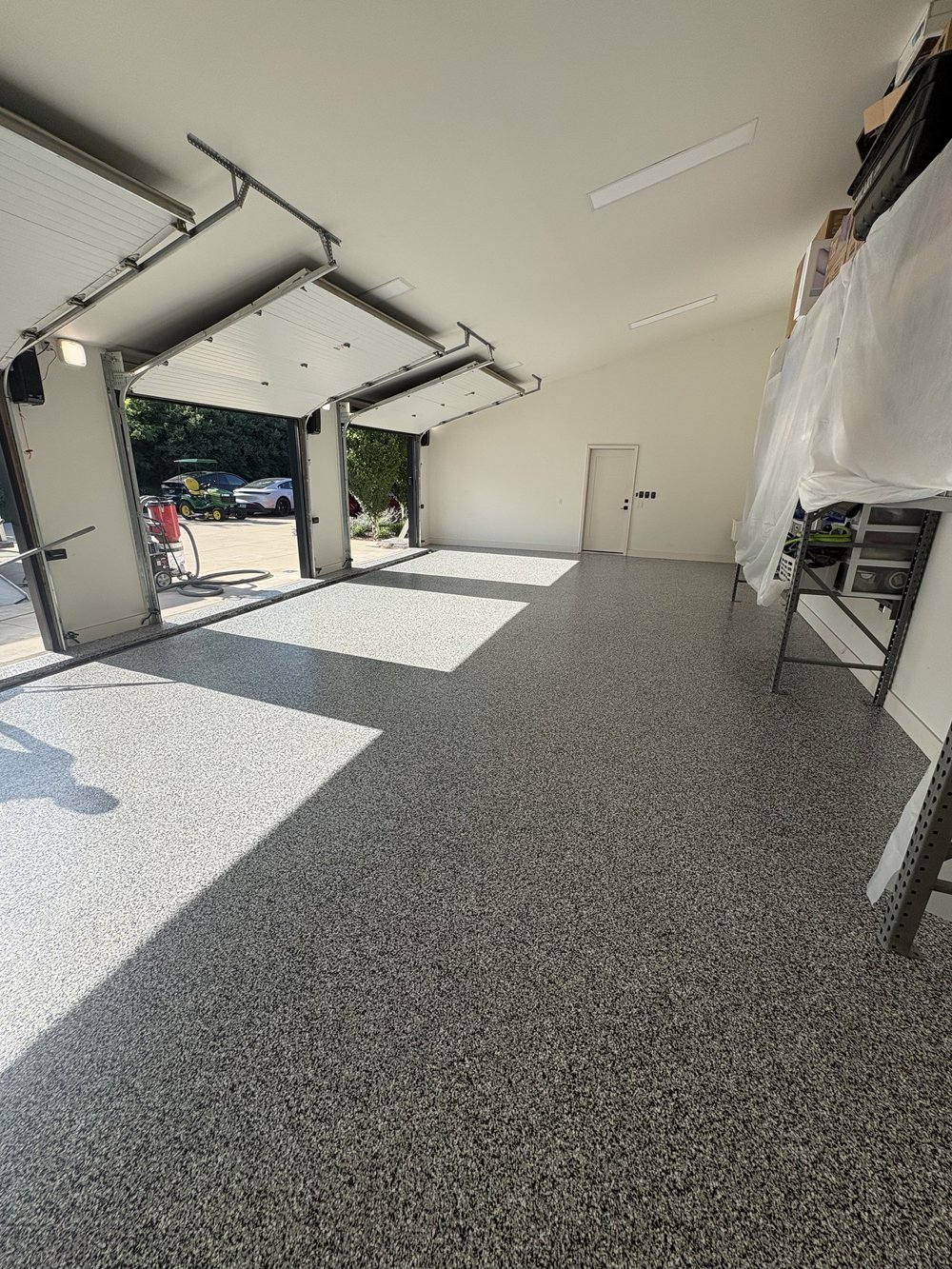 Garagem ampla branca com pavimento epoxy flake cinzento claro