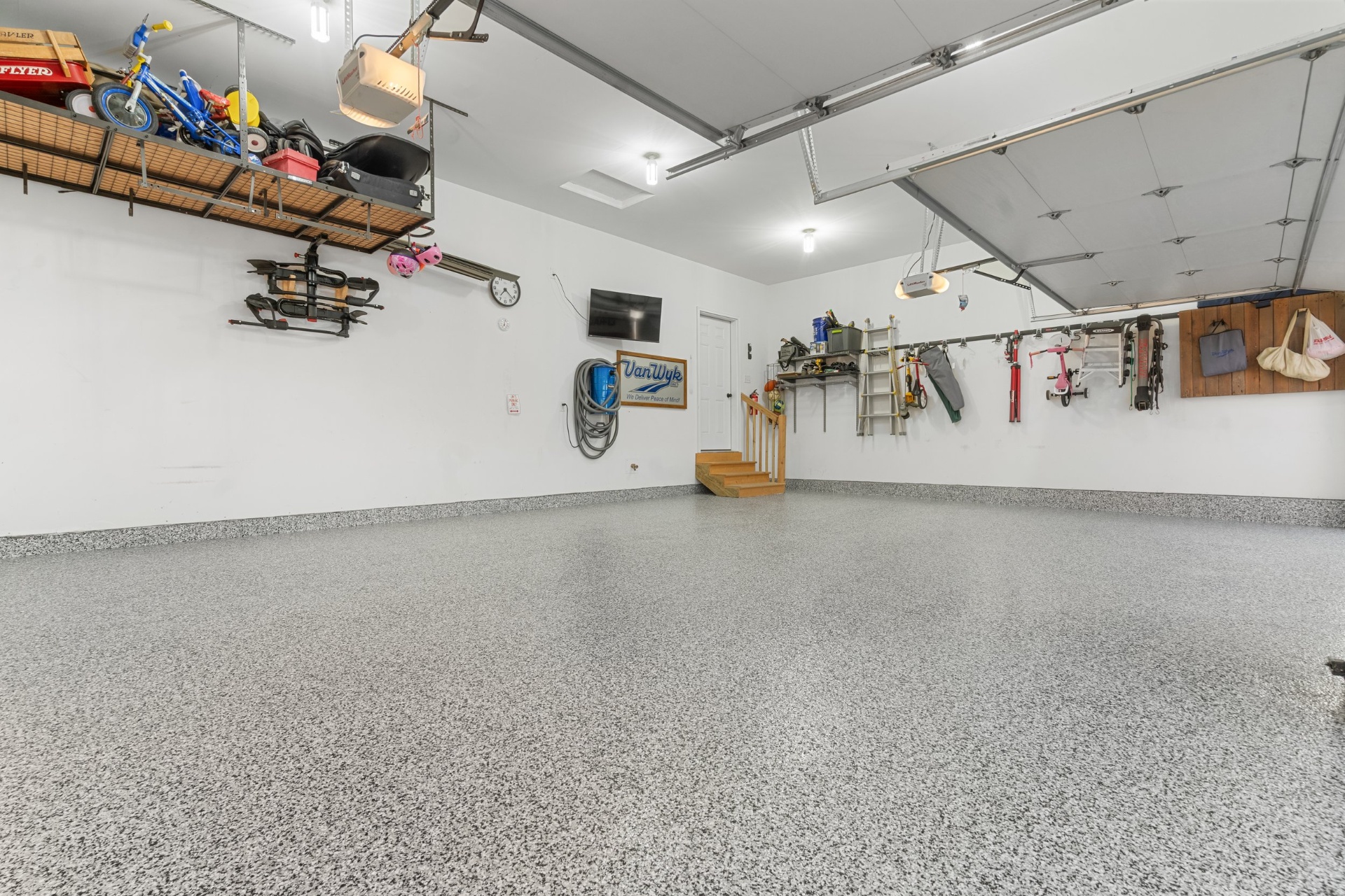 Garagem limpa com pavimento em flocos cinzentos e estantes de arrumação
